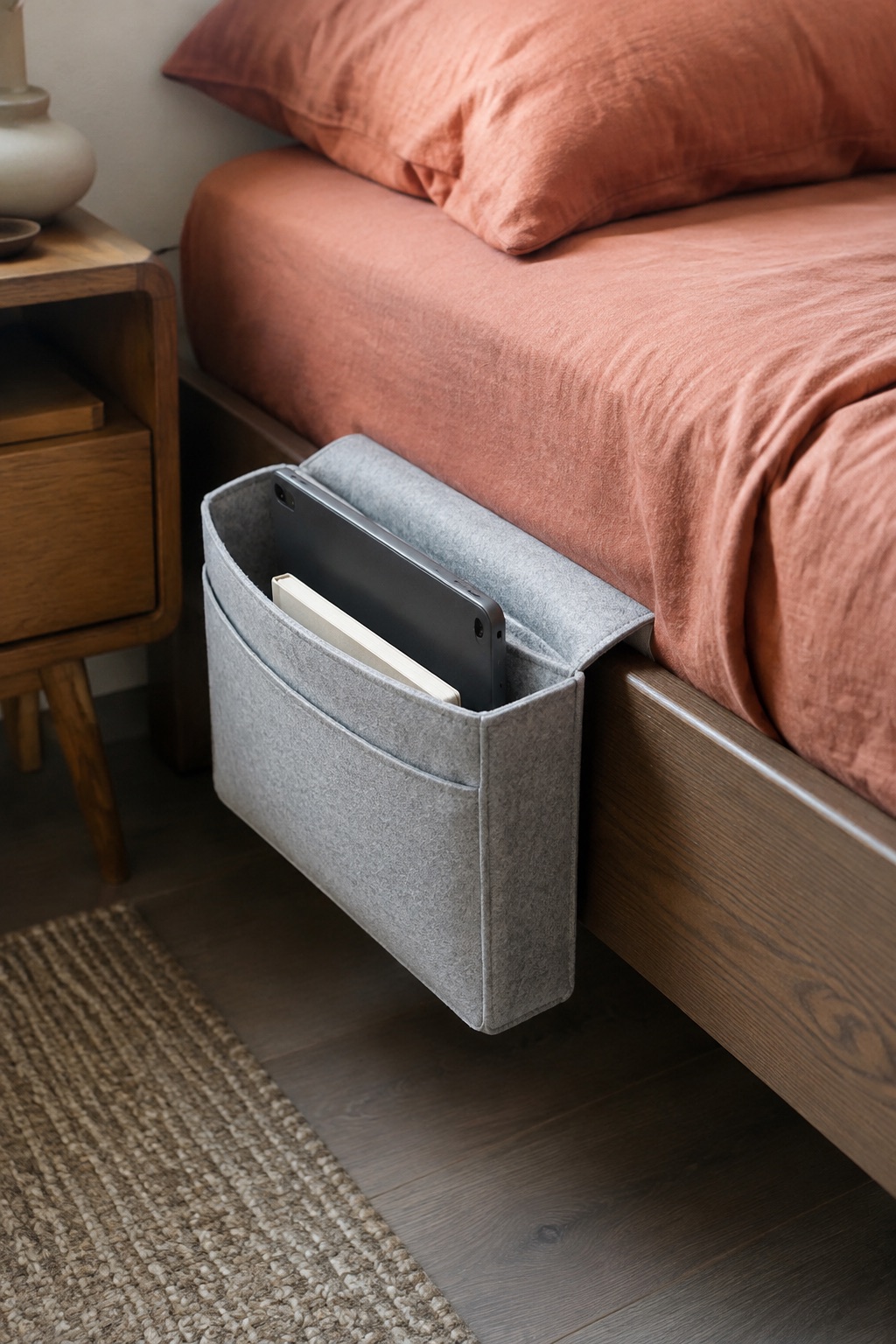 AI-generated visualization approximating the design of the LiB Original Large Bedside Caddy, Light Gray beside a bed.